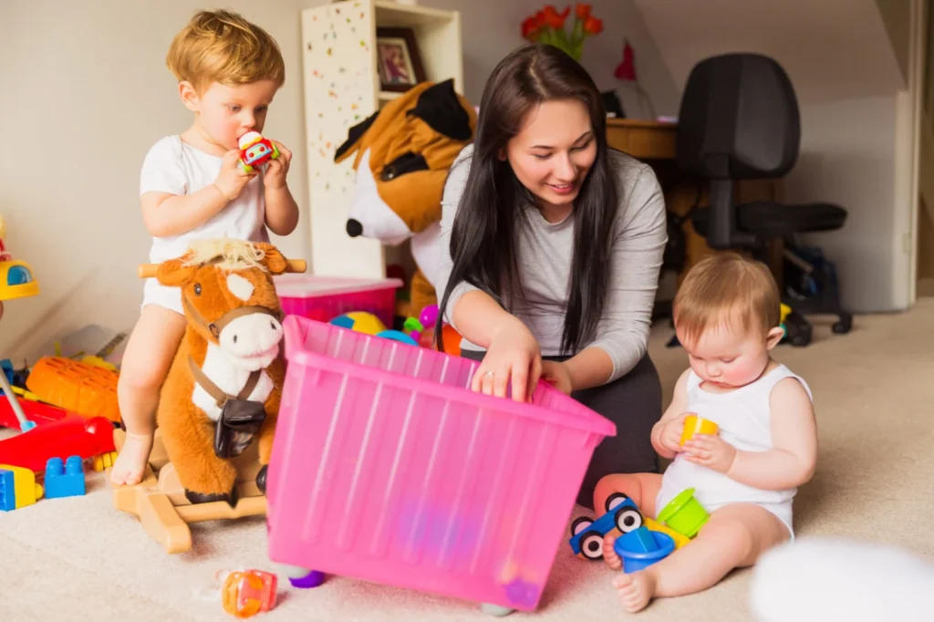 Nounou jouant avec deux enfants dans une chambre